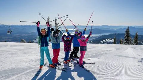 group of skiers in lesson, excited with their poles up