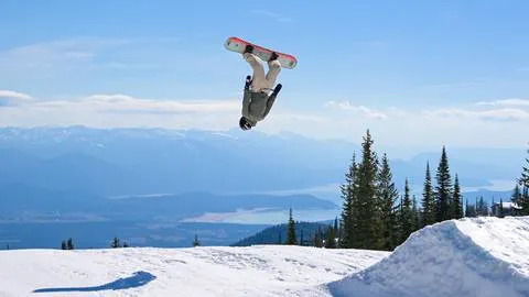 a snowboarder performs tricks at schweitzer mountain resort with the unlimited access of 2025/2026 season passes