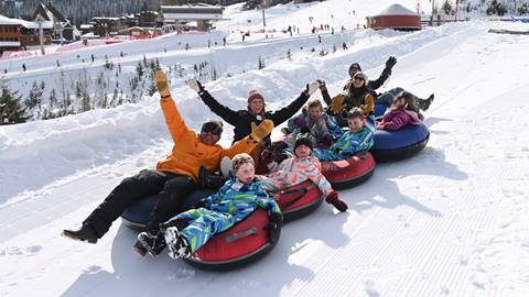 smiling family on tubing hill at hermit's hollow snow tubing schweitzer mountain resort