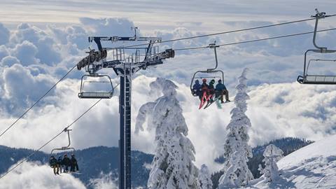group of riders on chairlift with dramatic clouds in the background