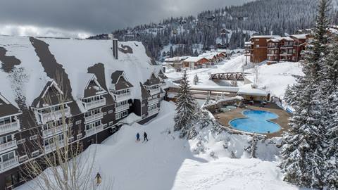 selkirk lodging skiers passing by selkirk lodge at schweitzer