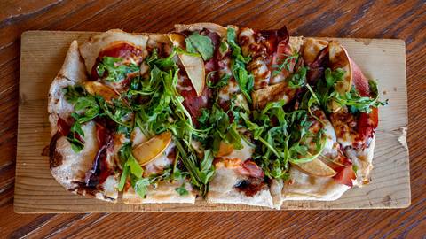 image of flatbread with arugula, pears, balsamic, and cheese at Gourmandie