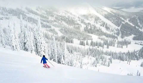 skier going down run with slopes background