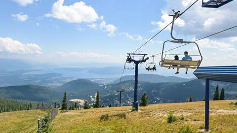 Guests enjoying a scenic chairlift ride at Schweitzer with panoramic views of lake pend oreille and the surrounding mountain landscape