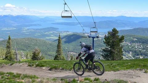A person mountain biking with lifts in the background at Schweitzer