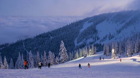 picture of multiple people skiing and riding at Schweitzer during twilight ski hours